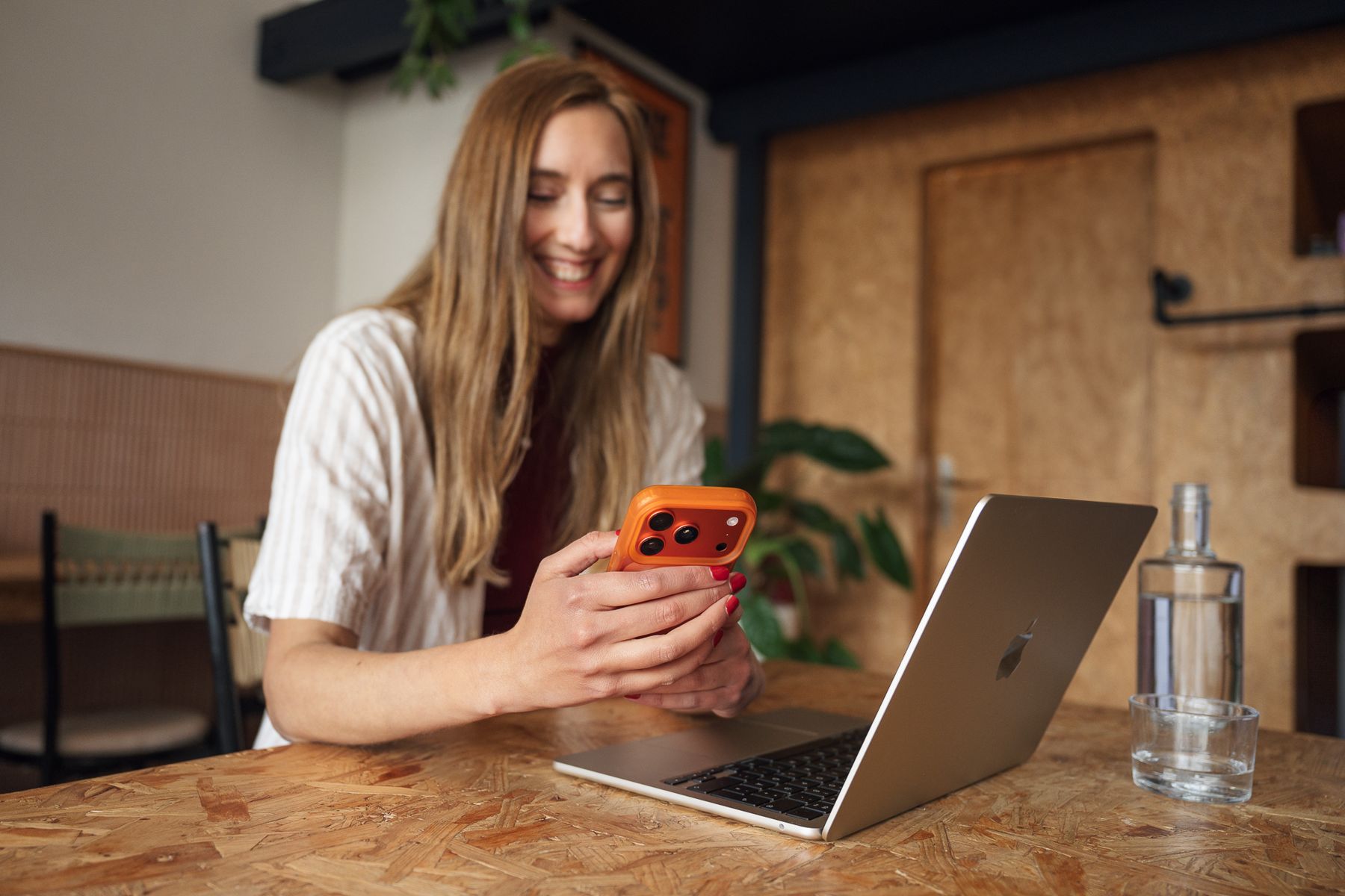 Corinna Reupke am Laptop mit Smartphone in der Hand